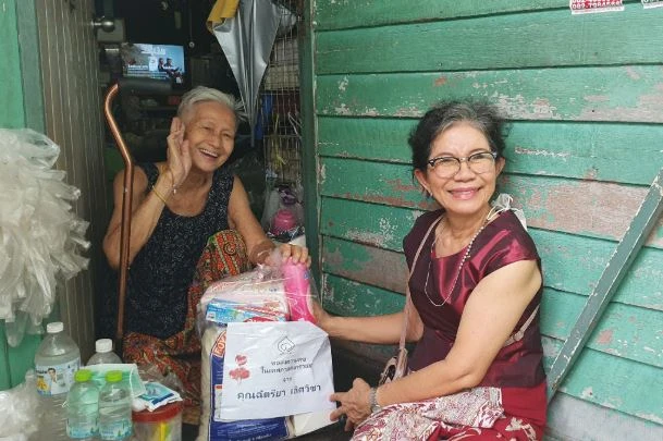 Amanda Jewellery team member delivering a care package to an elderly resident supported by the Duang Prateep Foundation, Bangkok