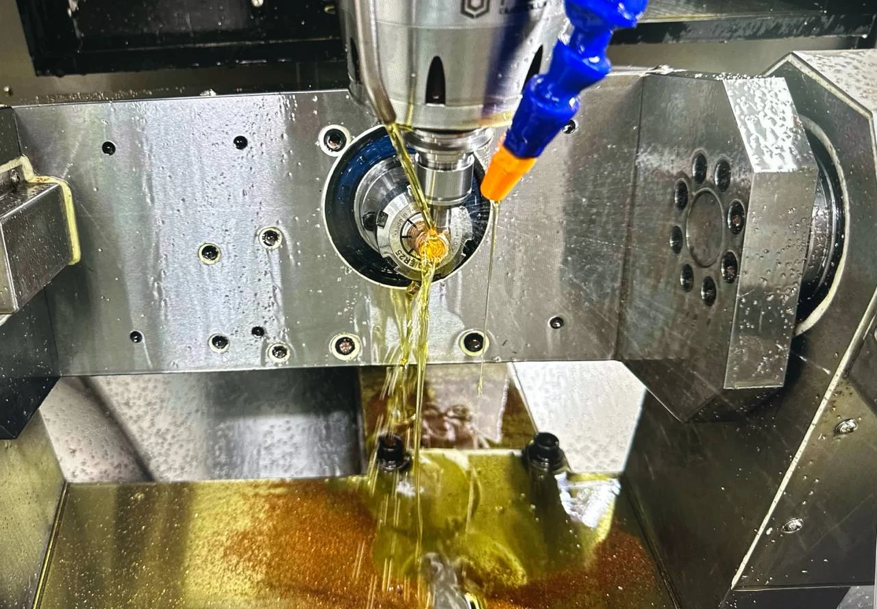 CNC machine spindle with amber coolant fluid in operation at Amanda Jewellery manufacturing facility, Bangkok